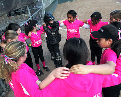 San Mateo youth softball players huddling before a game