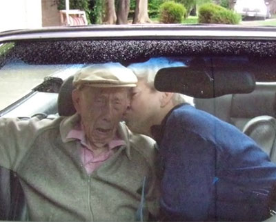 An image of an old lady kissing her husband on the cheek