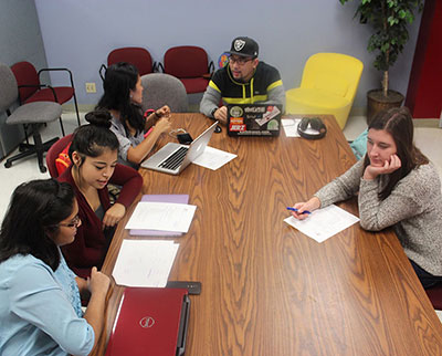 A group of students are meeting around a table