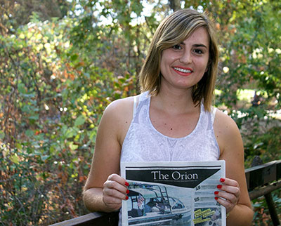 Risa Johnson holding a copy of The Orion