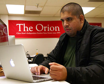 Gabriel Sandoval sitting in front of his laptop typing
